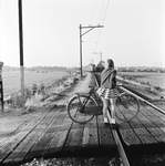 167640 Afbeelding van een meisje met haar fiets op een onbewaakte spoorwegovergang tussen Baarn en Soestdijk (gemeente ...